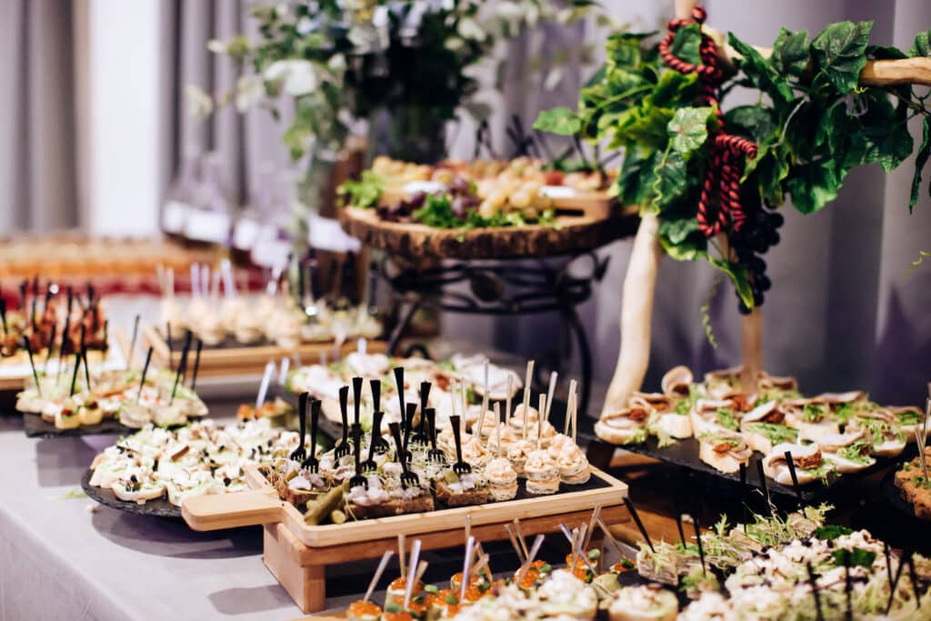 Table de buffet bien garnie avec assortiment de canapés, brochettes et bouchées apéritives.